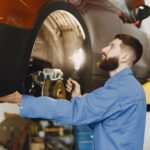 Certified car mechanic in Kenosha, WI performing a brake repair inspection on a vehicle rotor.