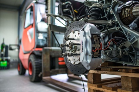 Certified car mechanic in Kenosha, WI performing a brake repair inspection on a vehicle rotor.